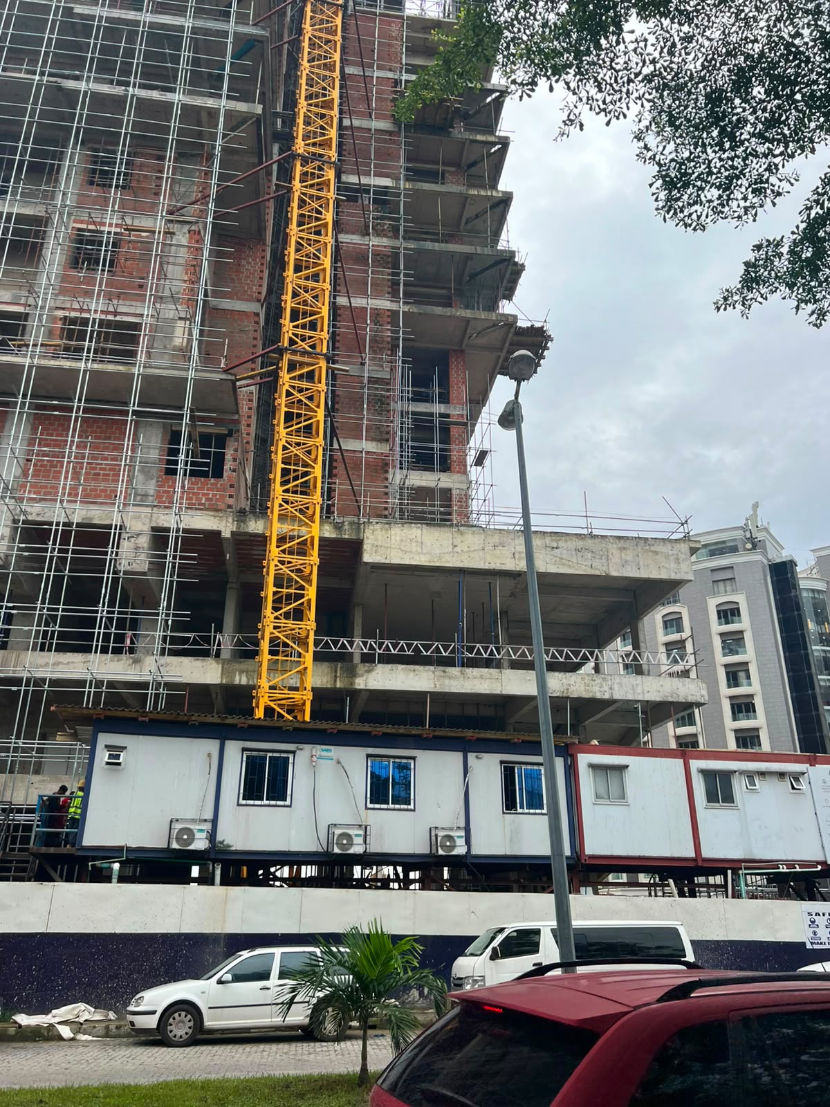 Tower under construction viewed from street level with crane